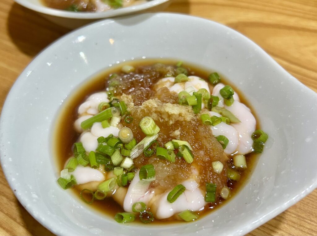 ネギ、生姜がたっぷり乗っている鱈の白子ポン酢