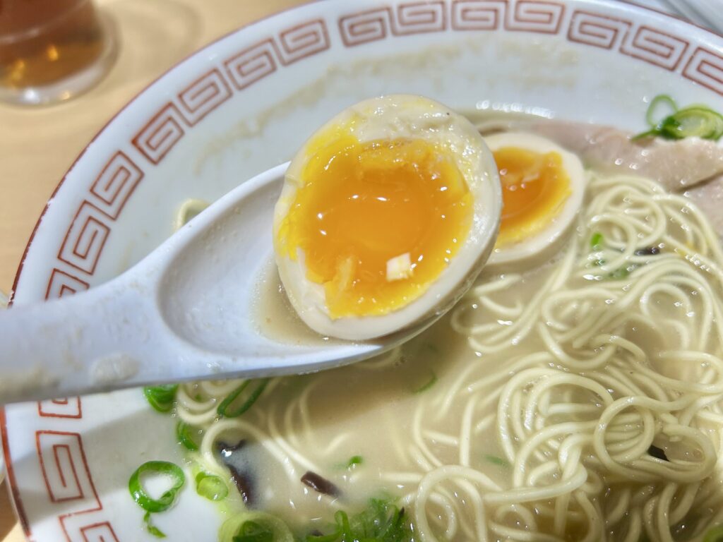 味玉を半分に割ってレンゲで上げている