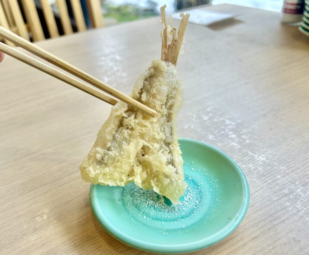 ホウボウの天ぷらに塩をつけている