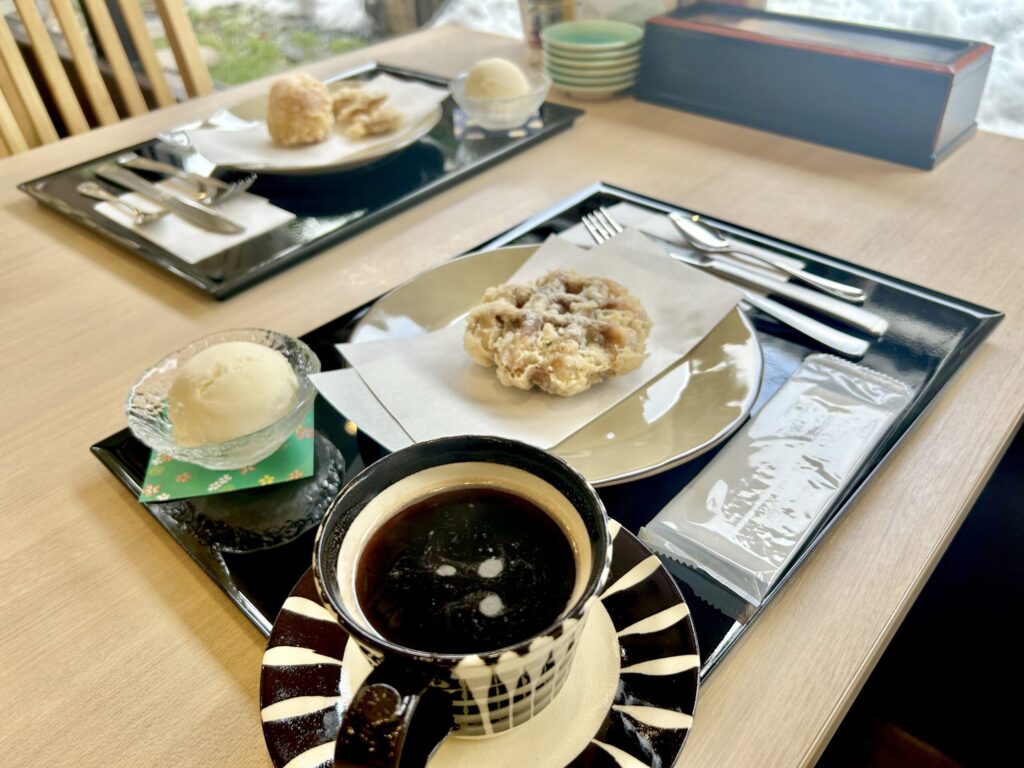 テーブルの上にコーヒ、バニラアイス、スイーツ天ぷらが乗っている