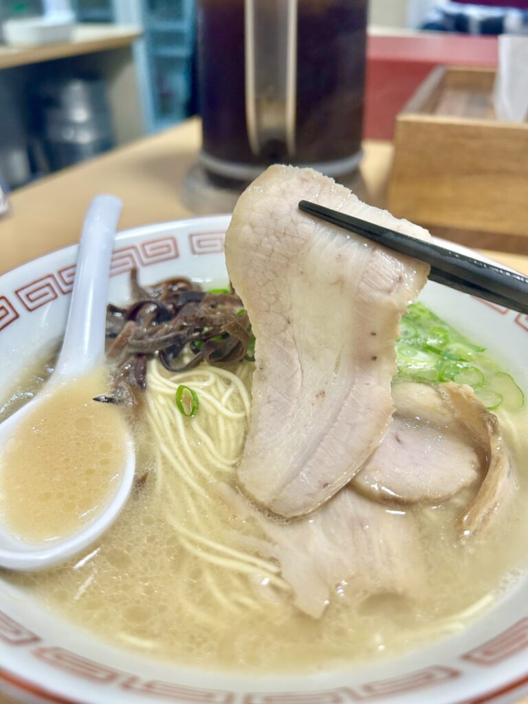 チャーシューを箸で持ち上げる