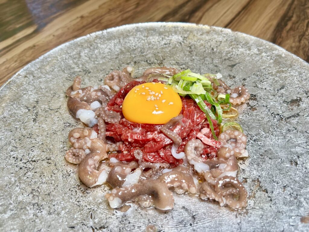 和牛のユッケと生きたテナガダコのぶつ切りを合わせたユッケタンタンイ