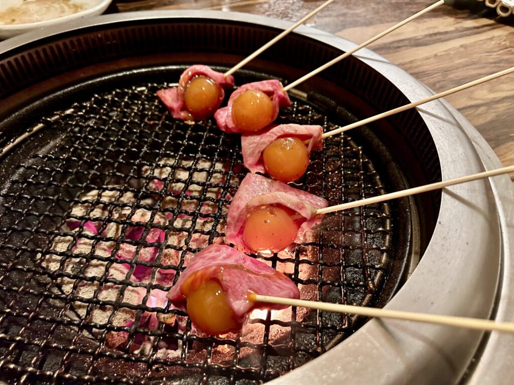 和牛卵黄包みを網の上で焼いている